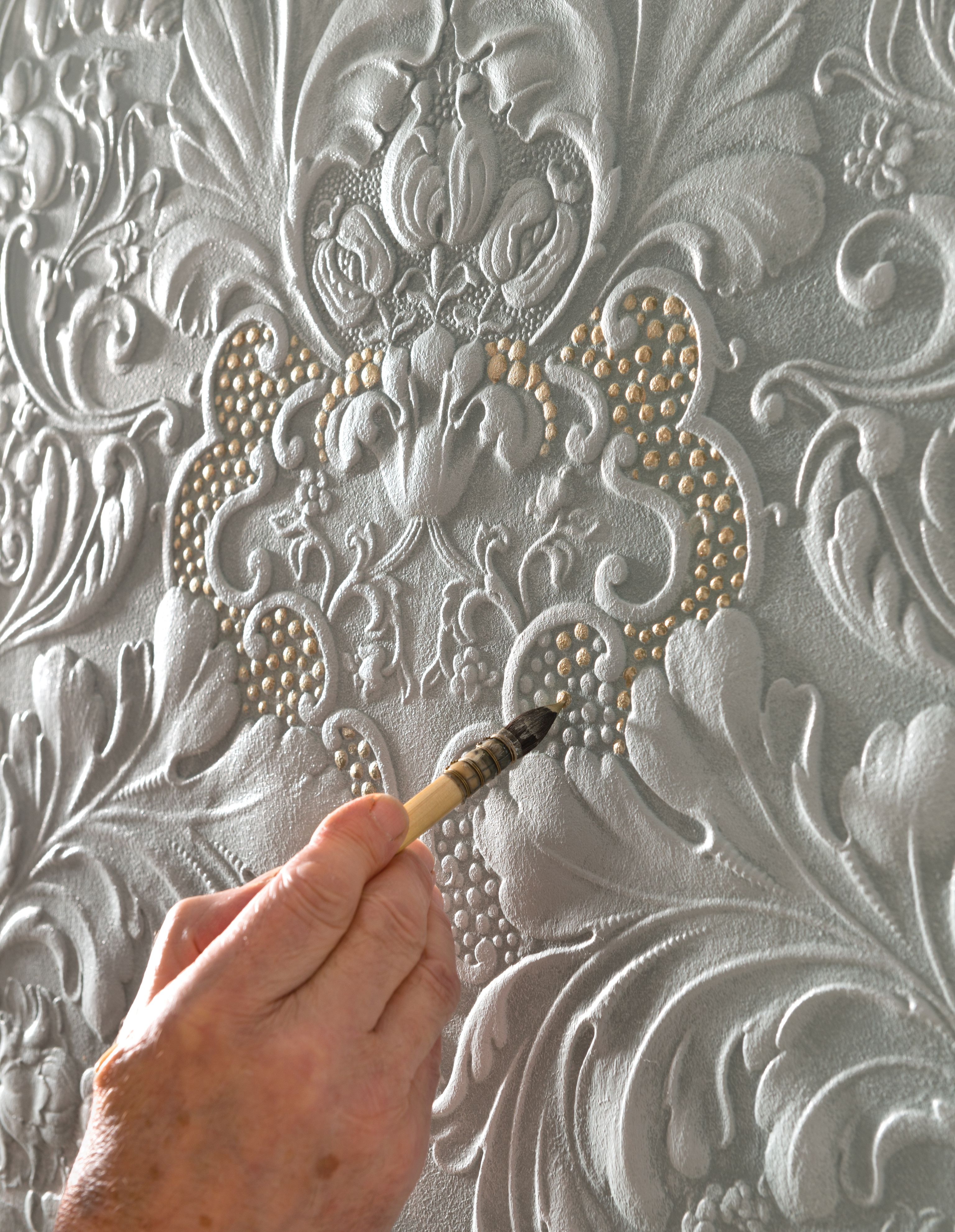 Image of person painting wallpaper using a paintbrush.